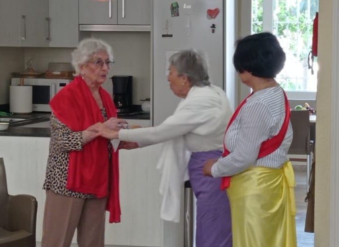 Tres mujeres mayores representando una obra de teatro en un centro de día