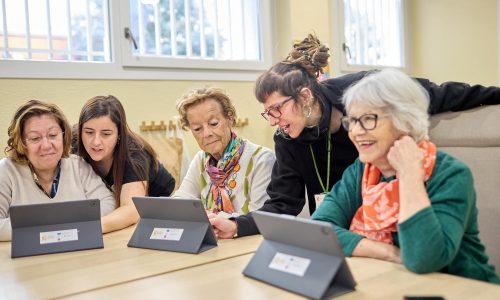 Personas mayores con tablets Tecnología para ejercitar la mente en un centro de estimulación cognitiva en Madrid