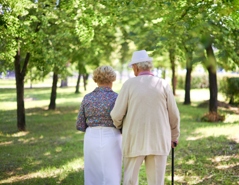 Personas mayores paseando por un parque en verano